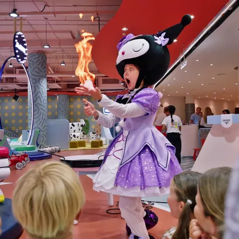 Costumed entertainer performing a fire trick for kids