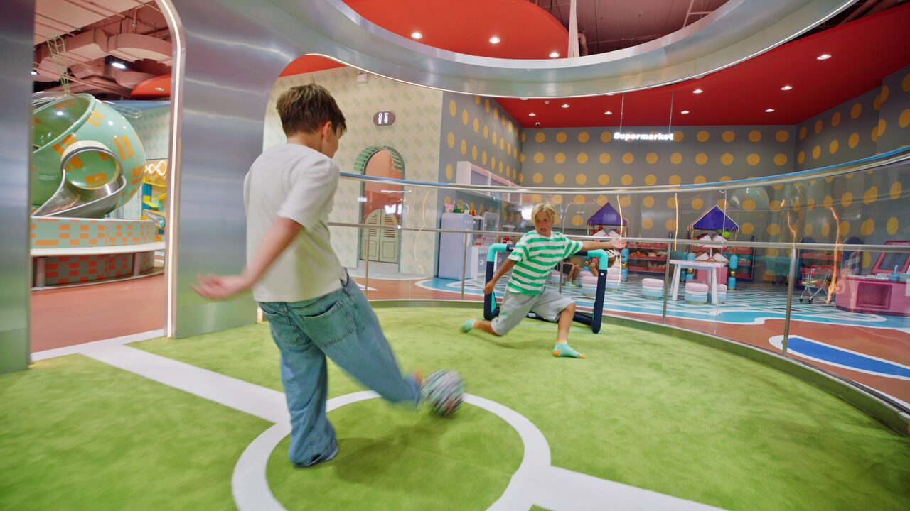 Kids playing football on the indoor play pitch