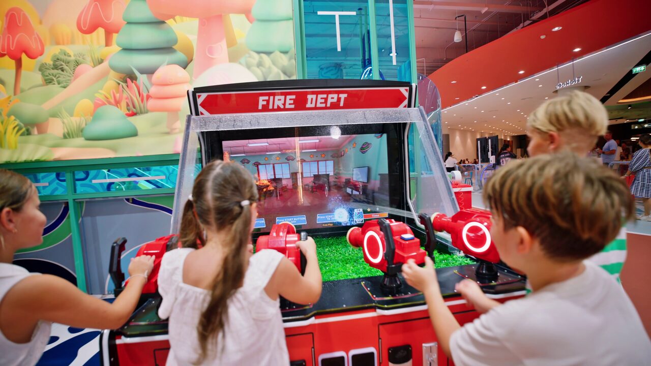 Children playing the Fire Dept interactive arcade game