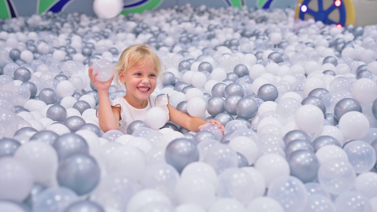 Girl playing in the pearl ball pit